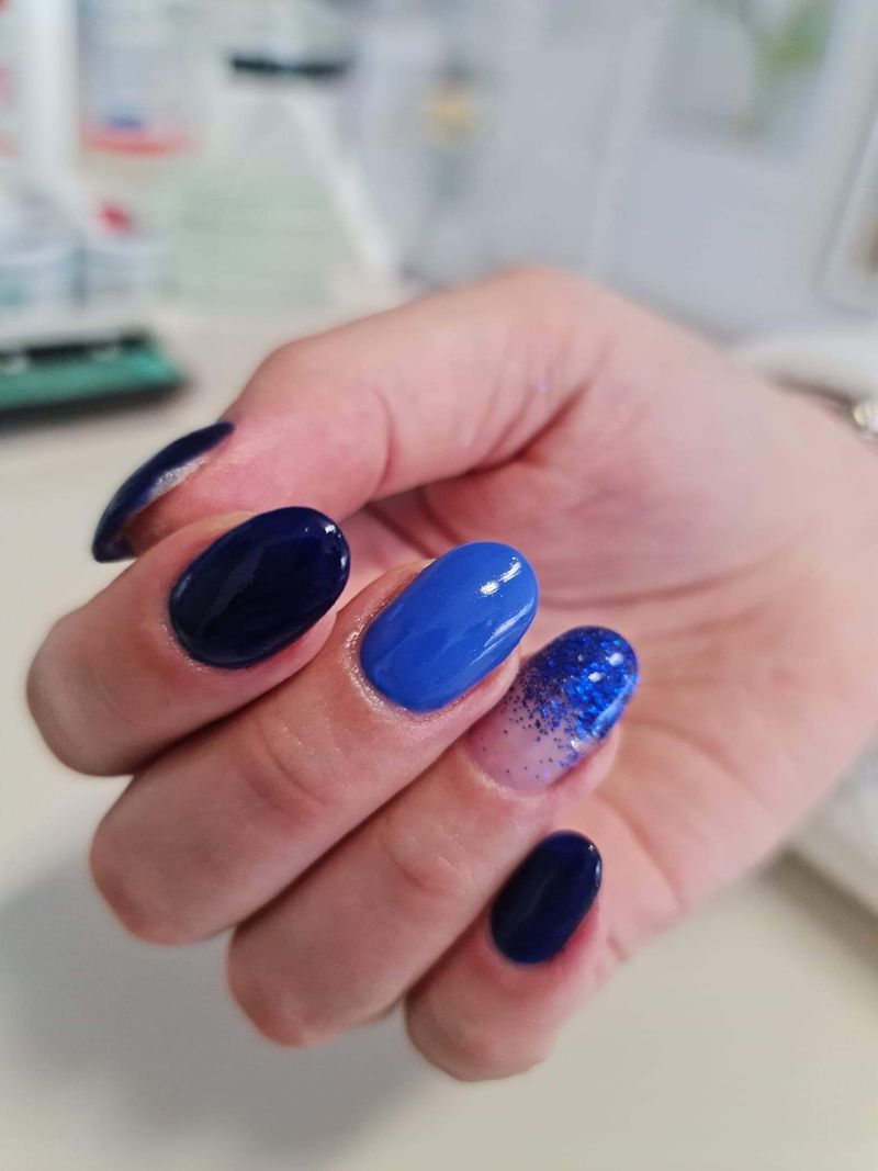 Runde Nägel in Dunkel- und Mittelblau mit Glitzerverlauf