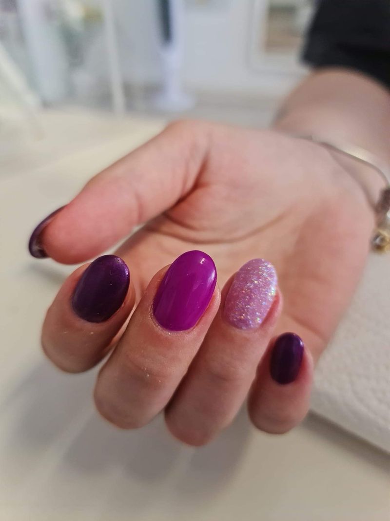 Runde Nägel in Lila und Pink mit einem Glitzernagel