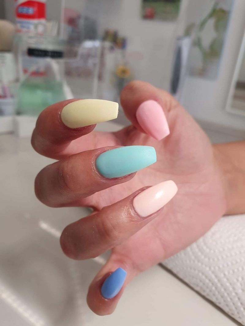 Lange Nägel in matten Pastellfarben, jeder Nagel in einer anderen Farbe
