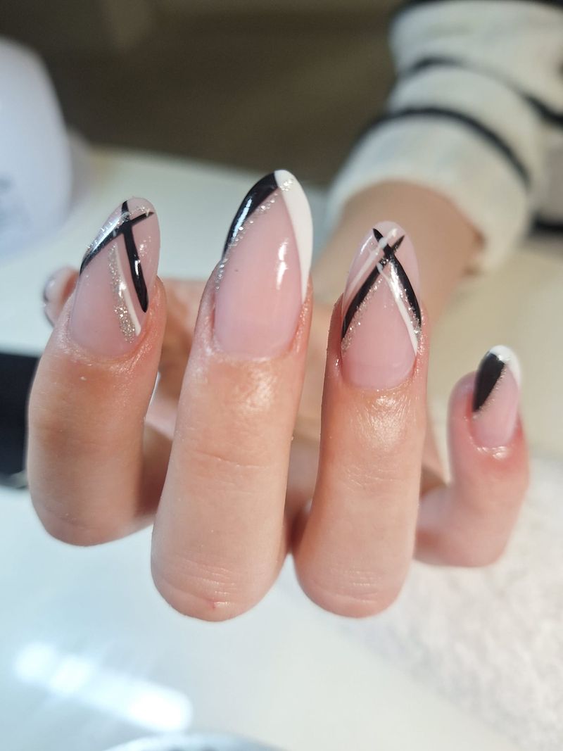 Mandelförmige Nägel mit feinen Linien in Schwarz, Weiß und Silber